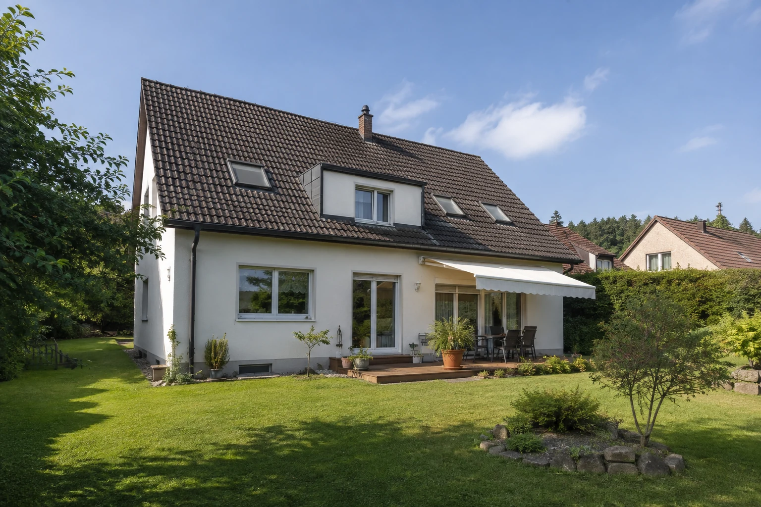 Helles gepflegtes Wohnhaus mit Terrasse, großen Fenstern und Garten